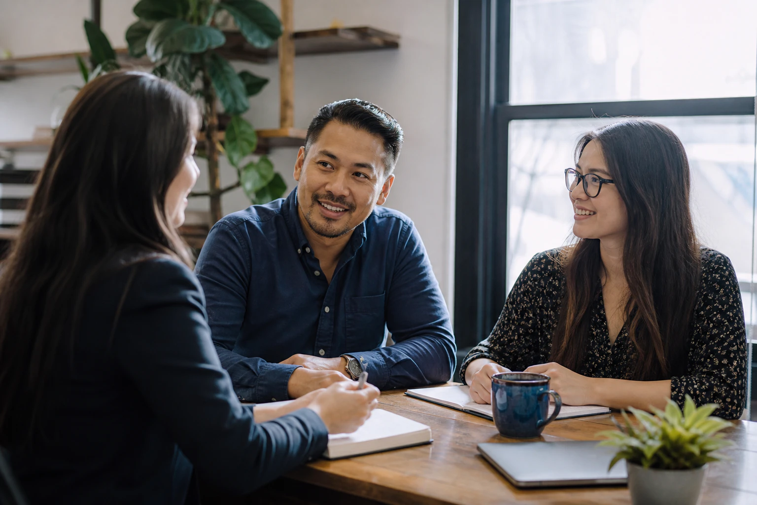 A professional advisor meeting with two small-business owners in a local office.